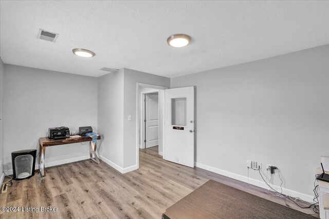 interior space with light hardwood / wood-style floors and a textured ceiling