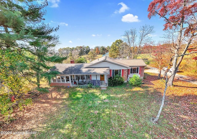 ranch-style home with covered porch and a front yard