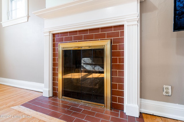 room details with wood-type flooring and a tile fireplace