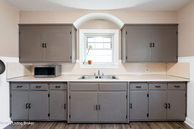 kitchen with gray cabinetry, dark hardwood / wood-style flooring, and sink