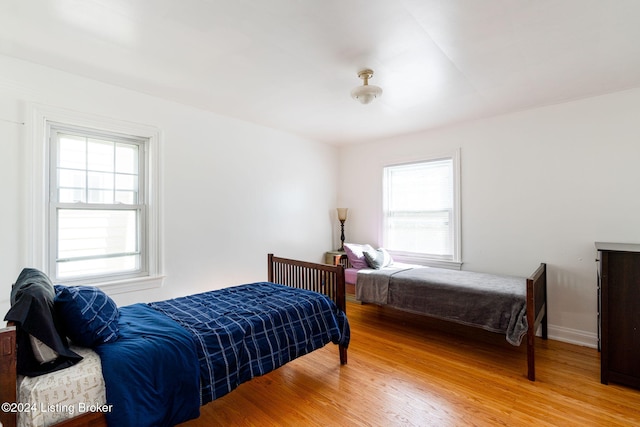 bedroom with wood-type flooring and multiple windows