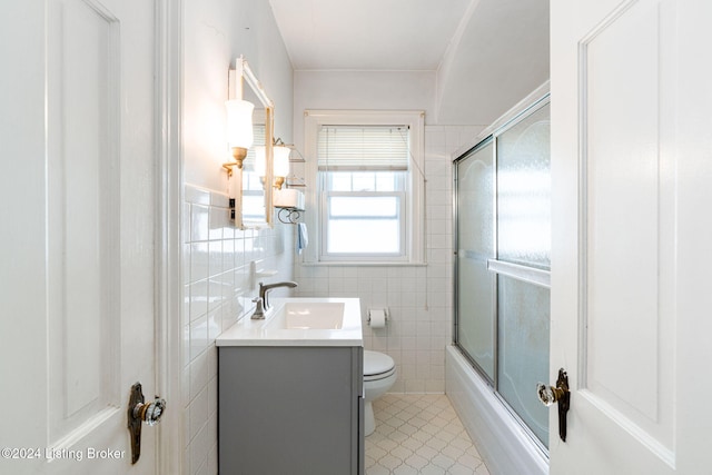 full bathroom with vanity, enclosed tub / shower combo, tile walls, and toilet