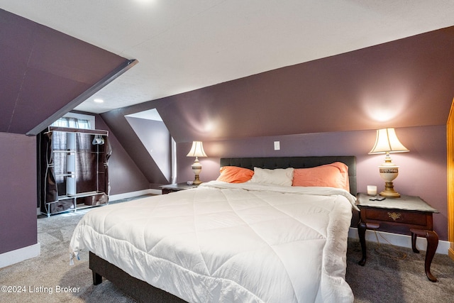 carpeted bedroom with lofted ceiling