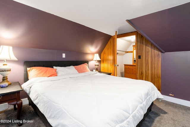 bedroom featuring carpet floors, wooden walls, and lofted ceiling