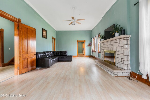 living room with ceiling fan, light hardwood / wood-style floors, and a fireplace