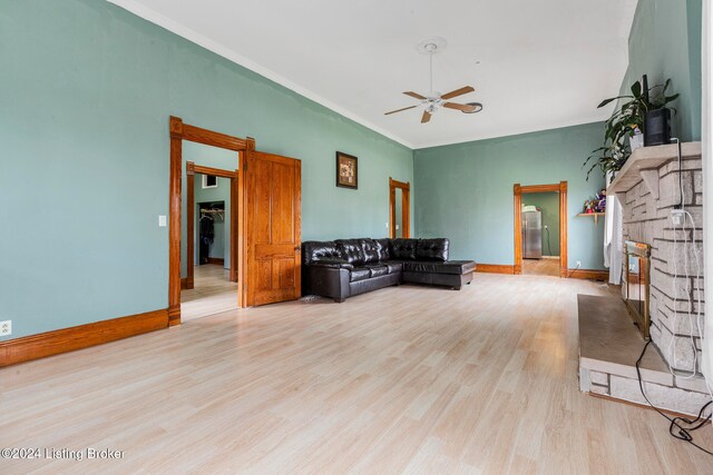 living room featuring ceiling fan, ornamental molding, and light hardwood / wood-style flooring