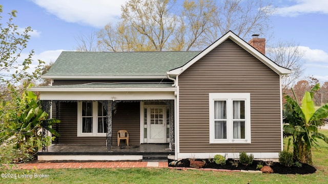 view of front of property featuring covered porch and a front lawn