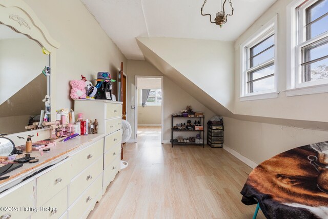 interior space with light hardwood / wood-style floors and vaulted ceiling