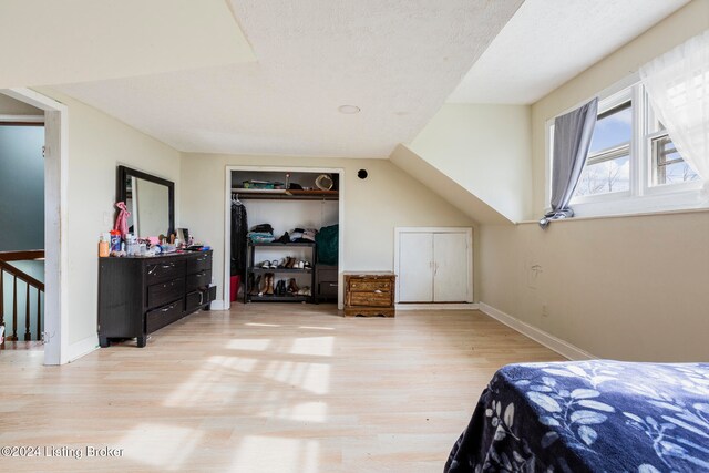 bedroom featuring a closet, a textured ceiling, and light wood-type flooring