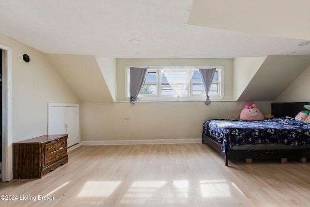 bedroom featuring vaulted ceiling and light hardwood / wood-style flooring