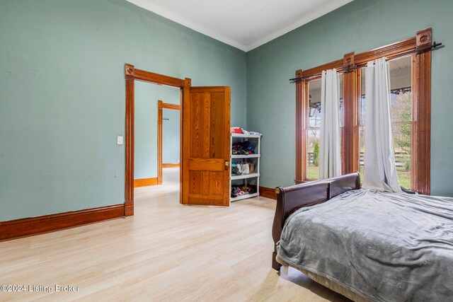 bedroom with crown molding and light hardwood / wood-style floors