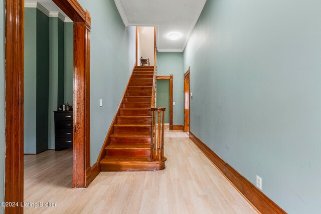 stairs featuring crown molding and hardwood / wood-style floors