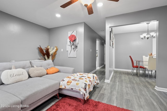 living room featuring wood-type flooring and ceiling fan with notable chandelier