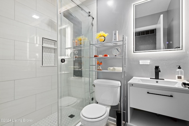 bathroom with vanity, a shower with shower door, and toilet