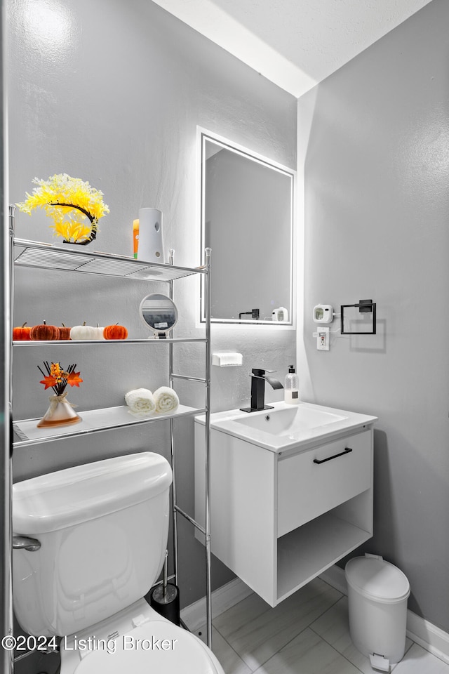 bathroom featuring tile patterned flooring, vanity, and toilet