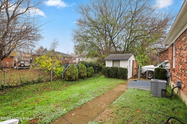 view of yard with central AC unit and a storage shed