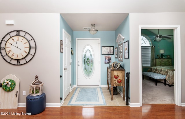 carpeted foyer entrance with ceiling fan