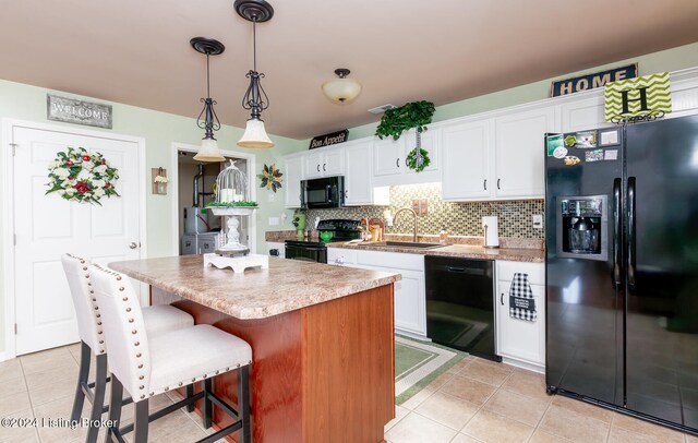 kitchen featuring sink, black appliances, white cabinets, a center island, and hanging light fixtures