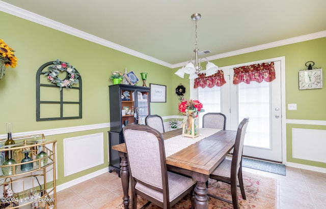 tiled dining space with a chandelier and ornamental molding