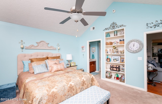 carpeted bedroom featuring a textured ceiling, ceiling fan, ensuite bathroom, and vaulted ceiling