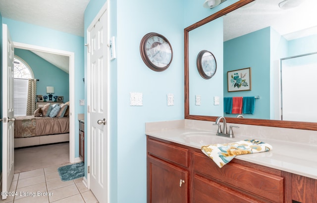 bathroom featuring walk in shower, vanity, a textured ceiling, tile patterned flooring, and lofted ceiling