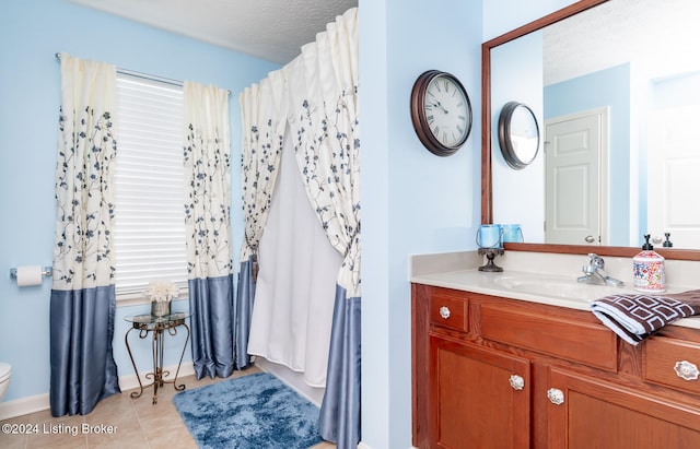 bathroom featuring tile patterned floors, vanity, a textured ceiling, and toilet