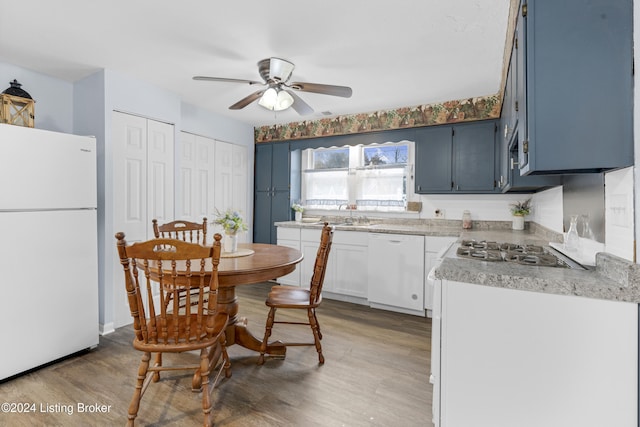 kitchen featuring light wood-type flooring, white appliances, blue cabinets, ceiling fan, and white cabinetry