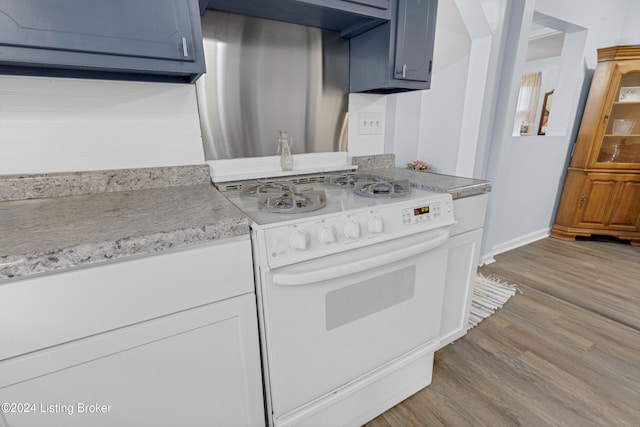 kitchen featuring white range oven, white cabinets, light hardwood / wood-style floors, and blue cabinets