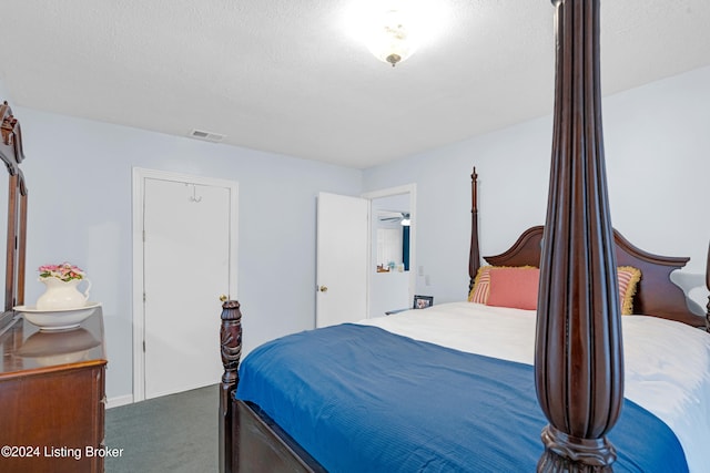 bedroom with carpet floors and a textured ceiling