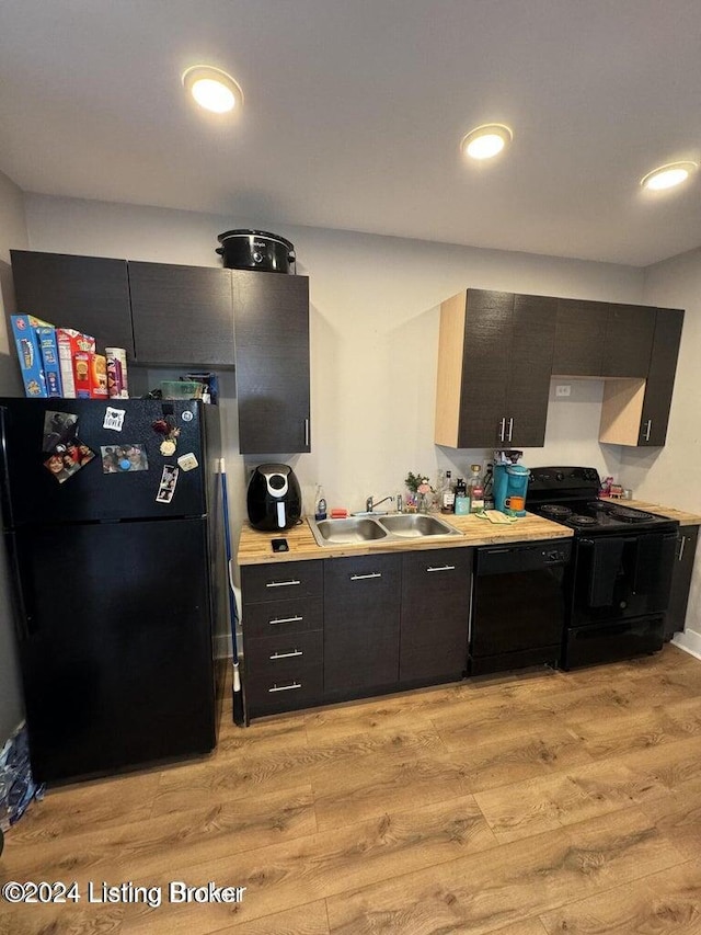 kitchen featuring black appliances, light wood-type flooring, and sink