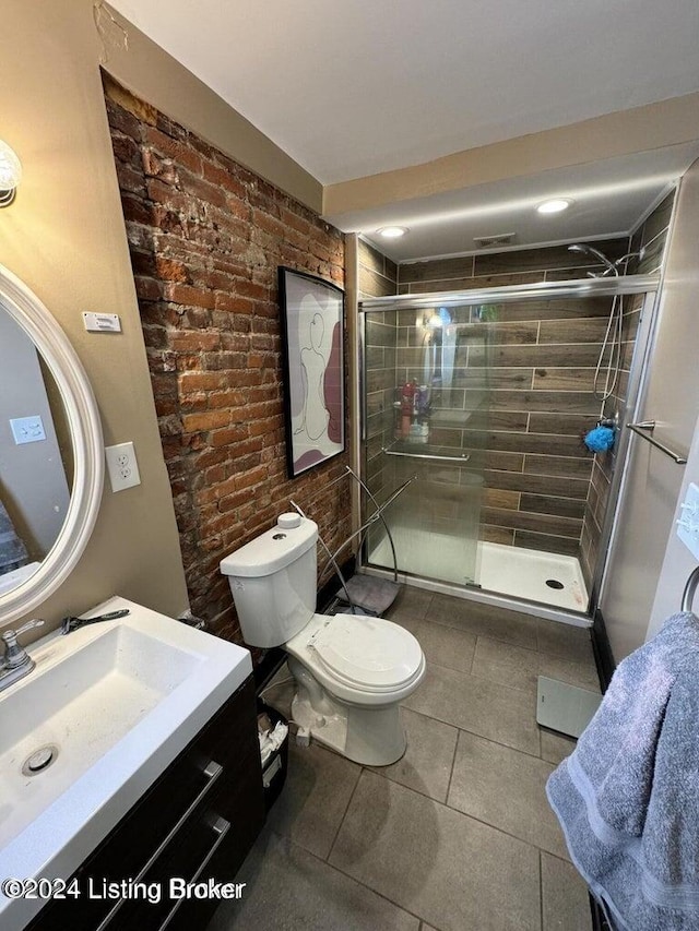 bathroom with tile patterned flooring, vanity, toilet, and a shower with shower door