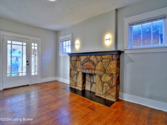 interior space with a fireplace, hardwood / wood-style floors, and a textured ceiling