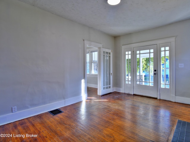 foyer featuring a textured ceiling and dark hardwood / wood-style flooring