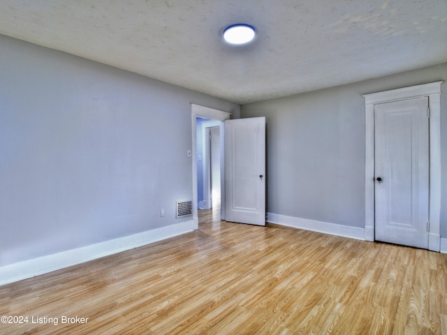 unfurnished bedroom featuring light hardwood / wood-style floors and a textured ceiling