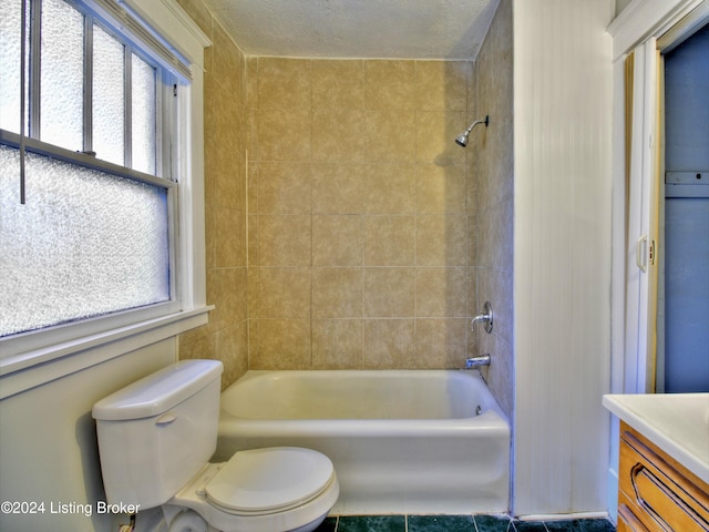 full bathroom with vanity, a textured ceiling, and a wealth of natural light