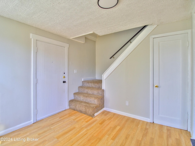 foyer with hardwood / wood-style floors and a textured ceiling