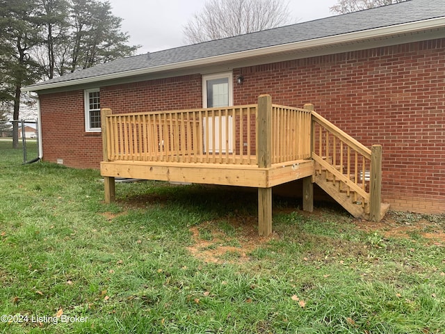 rear view of property with a wooden deck and a yard