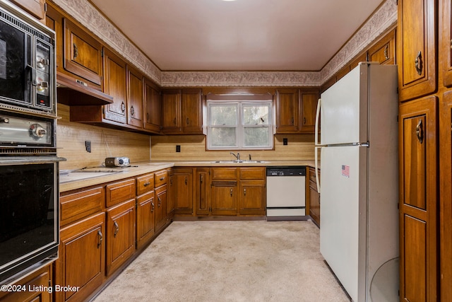 kitchen featuring black appliances, sink, light carpet, and tasteful backsplash