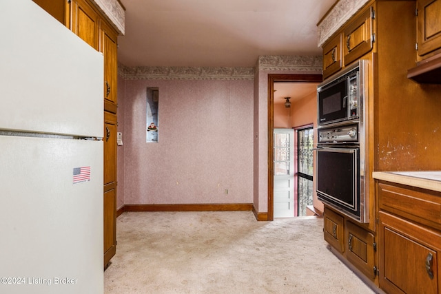 kitchen with light carpet, white refrigerator, black oven, and built in microwave