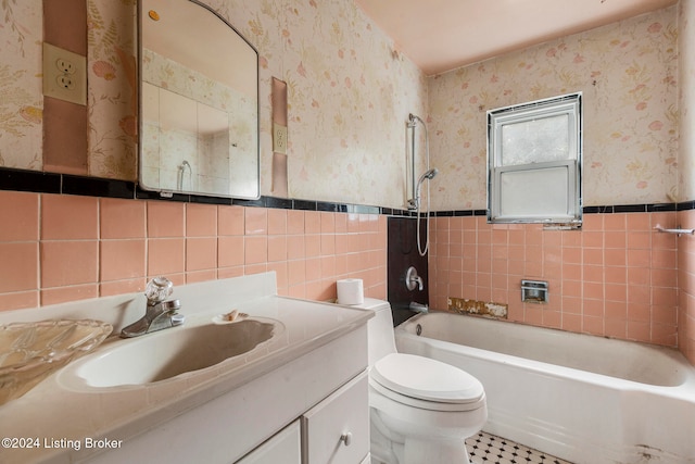 full bathroom featuring tile patterned flooring, bathing tub / shower combination, toilet, vanity, and tile walls