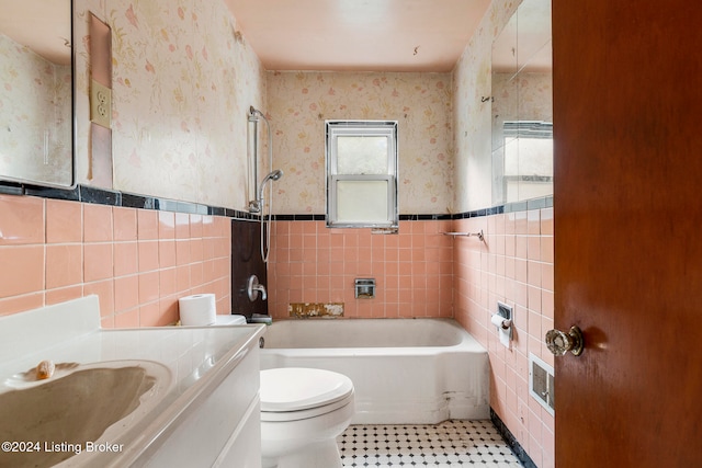 full bathroom with vanity, toilet, washtub / shower combination, and tile walls