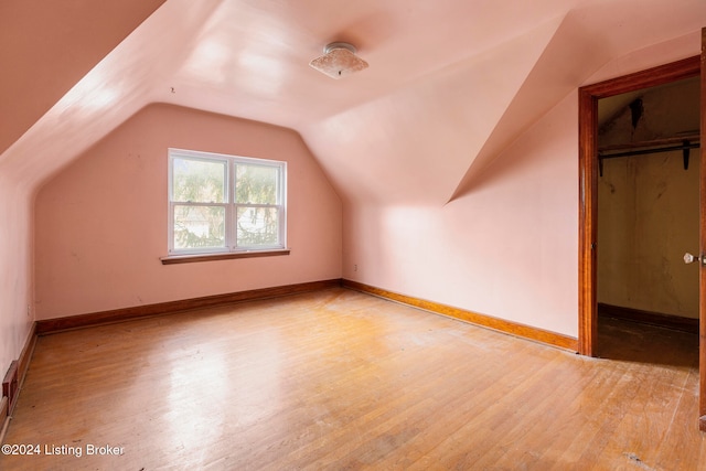 bonus room with lofted ceiling and light wood-type flooring