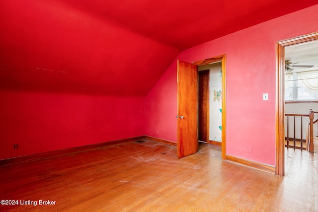 additional living space with hardwood / wood-style flooring, ceiling fan, and vaulted ceiling