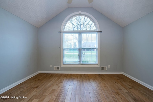 unfurnished room with ceiling fan, wood-type flooring, and vaulted ceiling