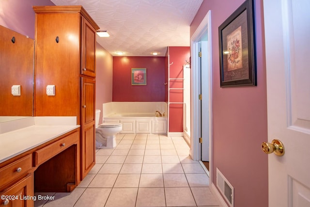 bathroom with a washtub, tile patterned floors, a textured ceiling, toilet, and vanity