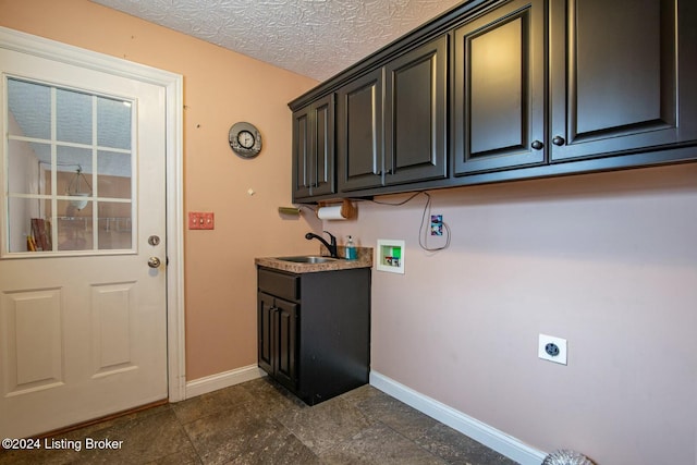 washroom with sink, cabinets, washer hookup, electric dryer hookup, and a textured ceiling