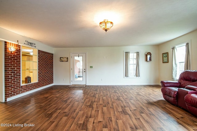 living room with a healthy amount of sunlight, a textured ceiling, and dark wood-type flooring