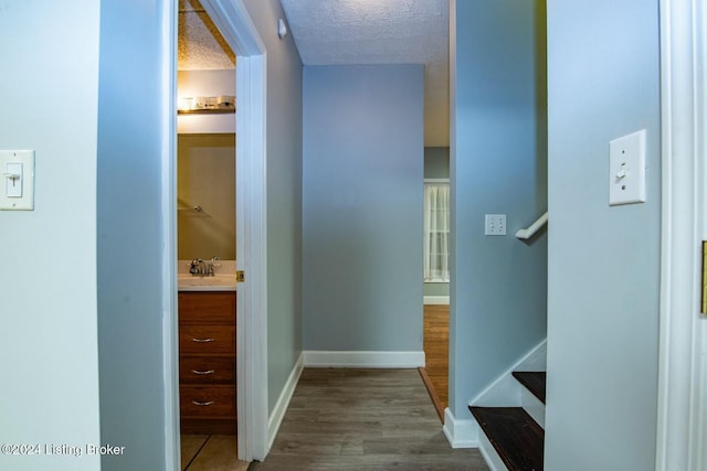 corridor featuring hardwood / wood-style floors and a textured ceiling