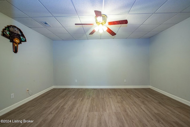 unfurnished room featuring wood-type flooring, a drop ceiling, and ceiling fan