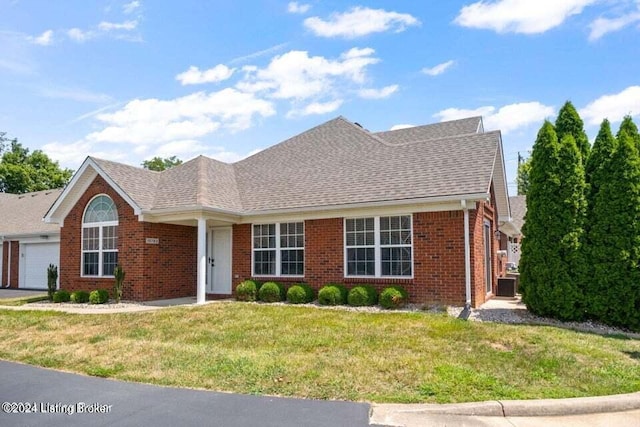 view of front of house featuring cooling unit, a front yard, and a garage